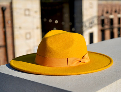 A yellow color large brim fashion hat with a yellow bowtie headband.